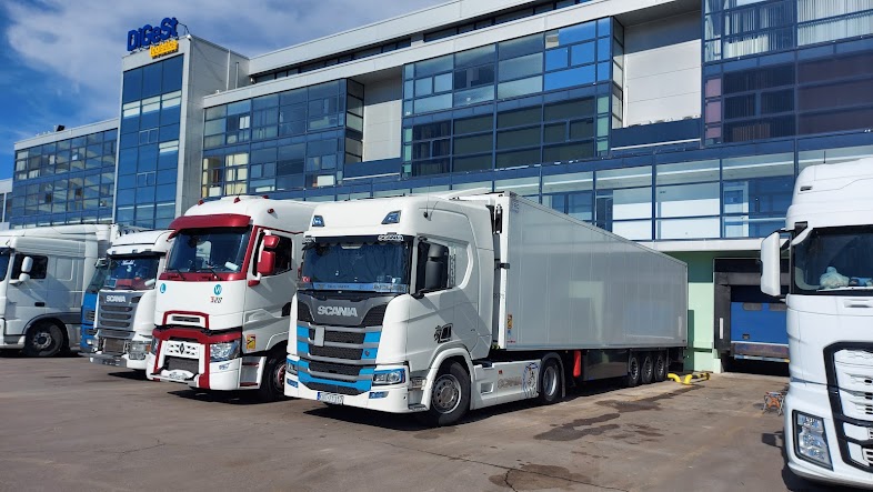 Row of commercial semi-trucks parked at DiGeSt logistics facility